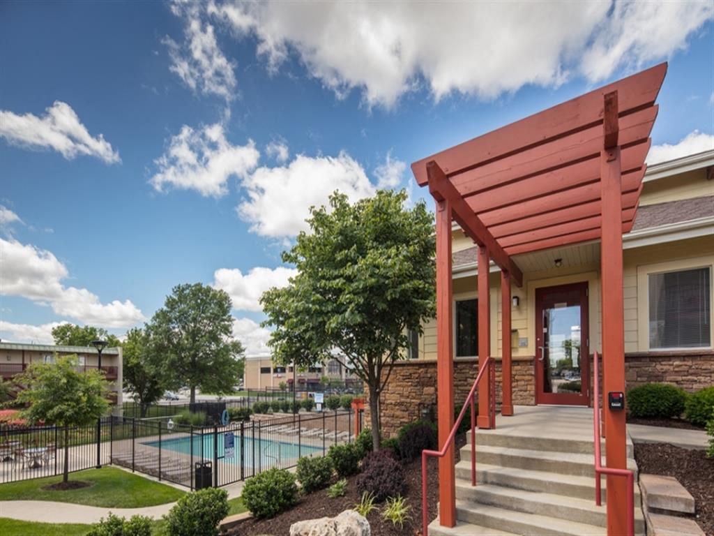 a building with a pool and a red covered porch