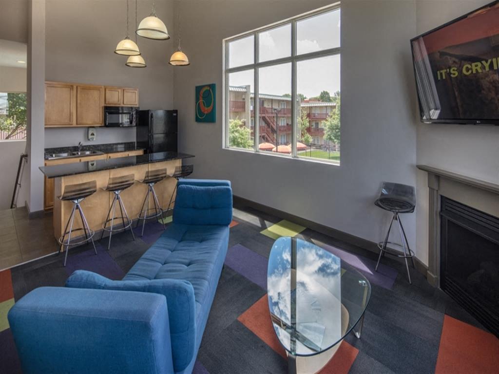 a living room with blue couches and a glass table