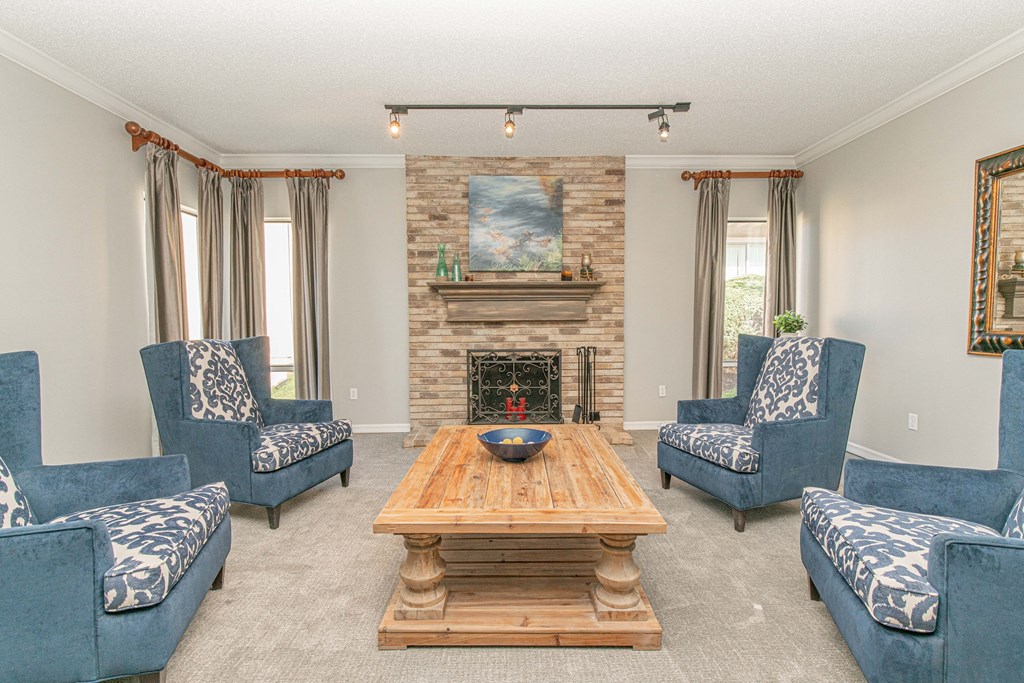 a living room with blue chairs and a fireplace