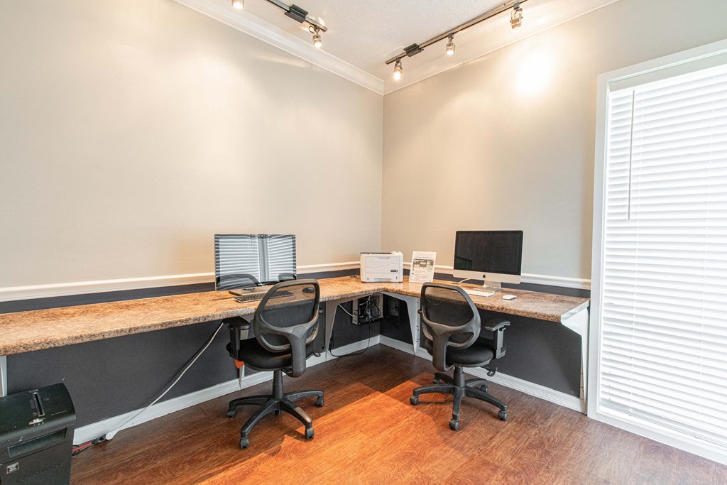 a home office with two desks and two computer monitors