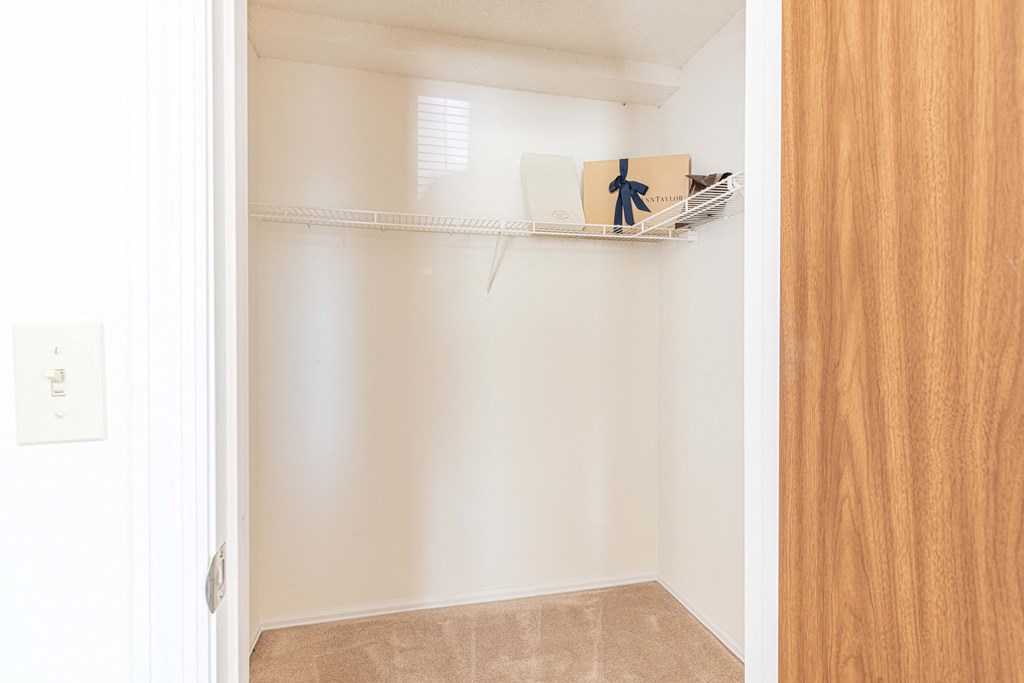 an empty closet with a shelf with a box on it