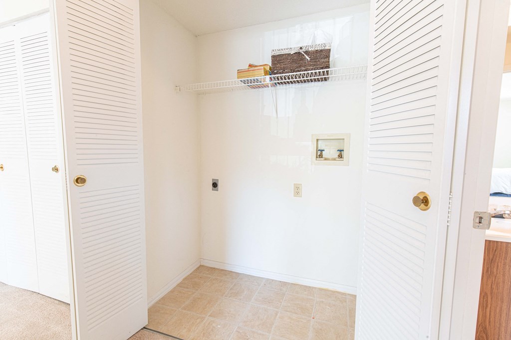 a bathroom with white shutters and a shower and a closet