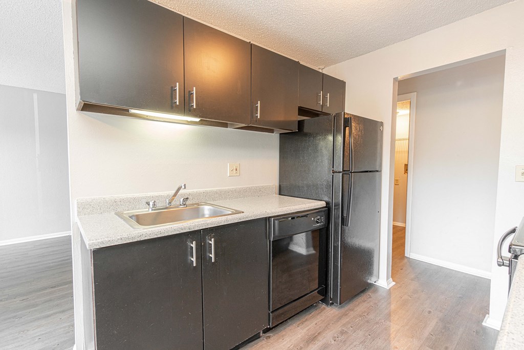 an empty kitchen with stainless steel appliances and a refrigerator