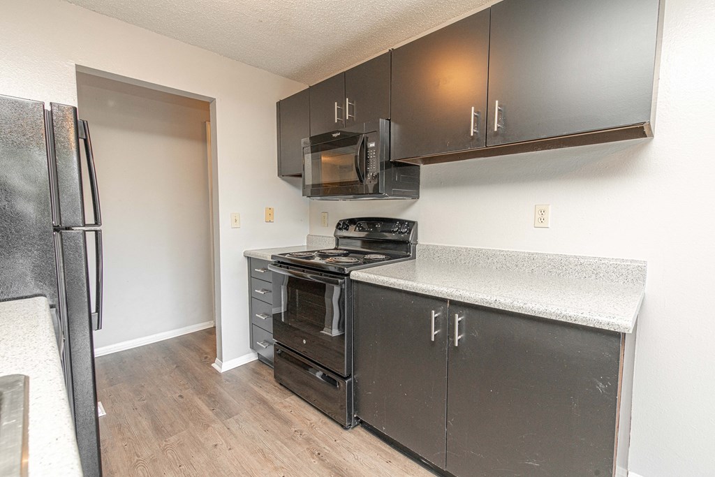 an empty kitchen with stainless steel appliances and a refrigerator