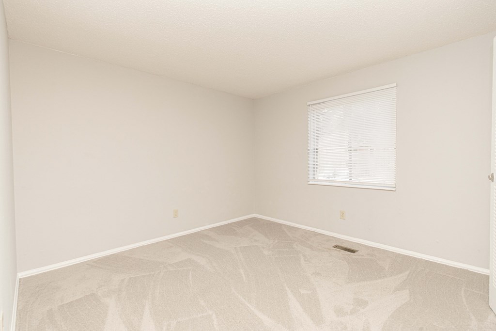 an empty room with white walls and a window