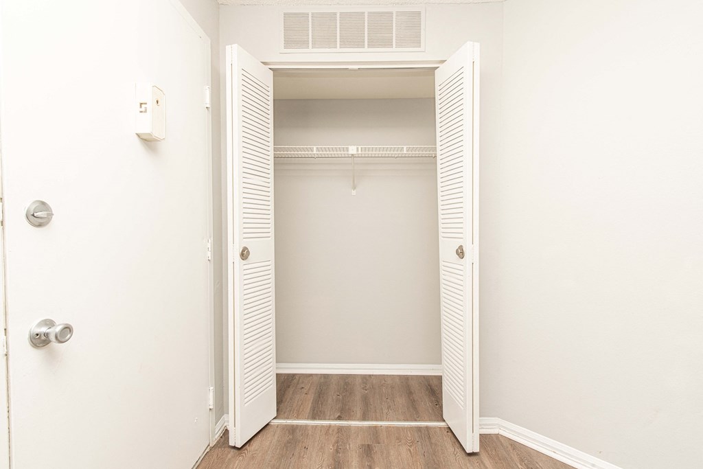 an empty closet in a room with wood floors and white walls