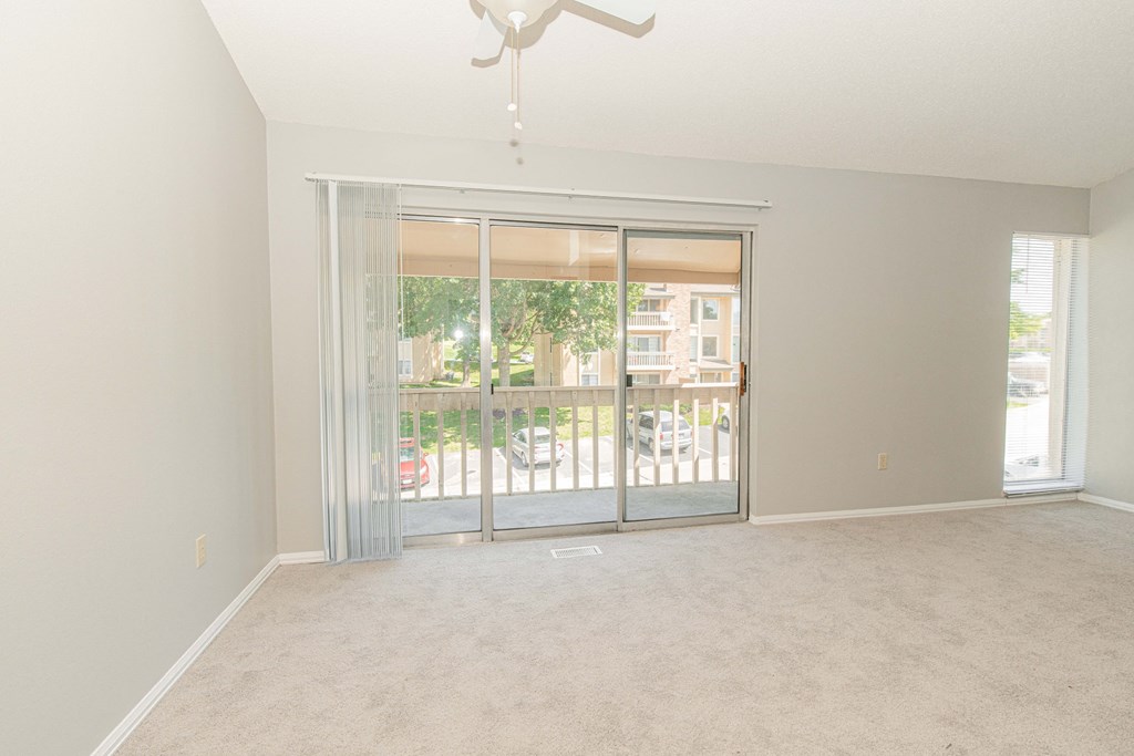 an empty living room with sliding glass doors to a balcony