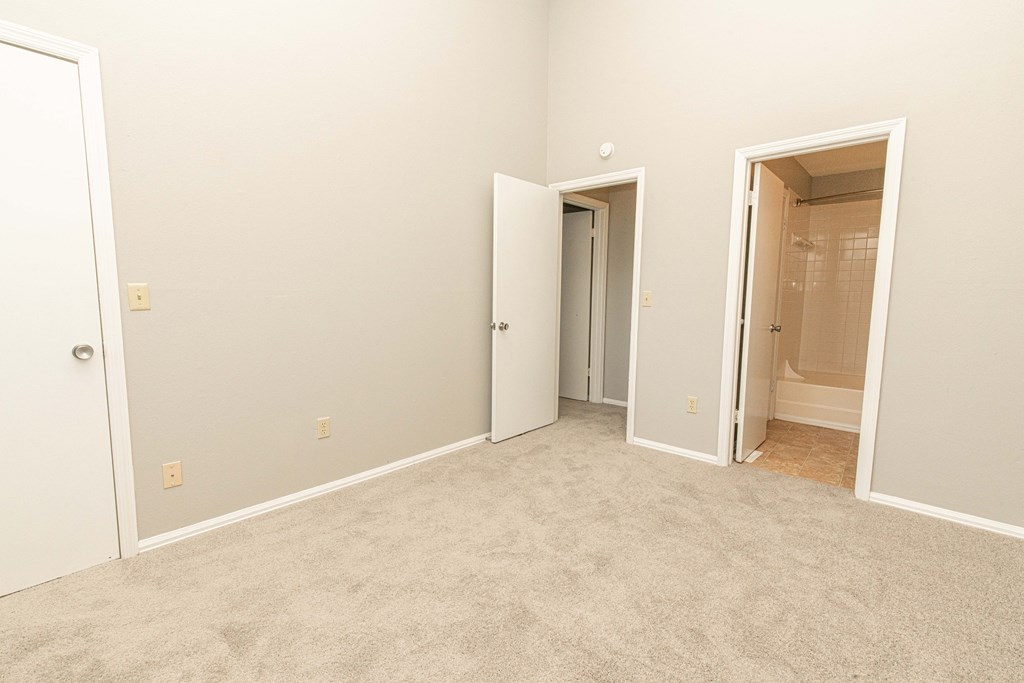 an empty bedroom with a closet and a bathroom
