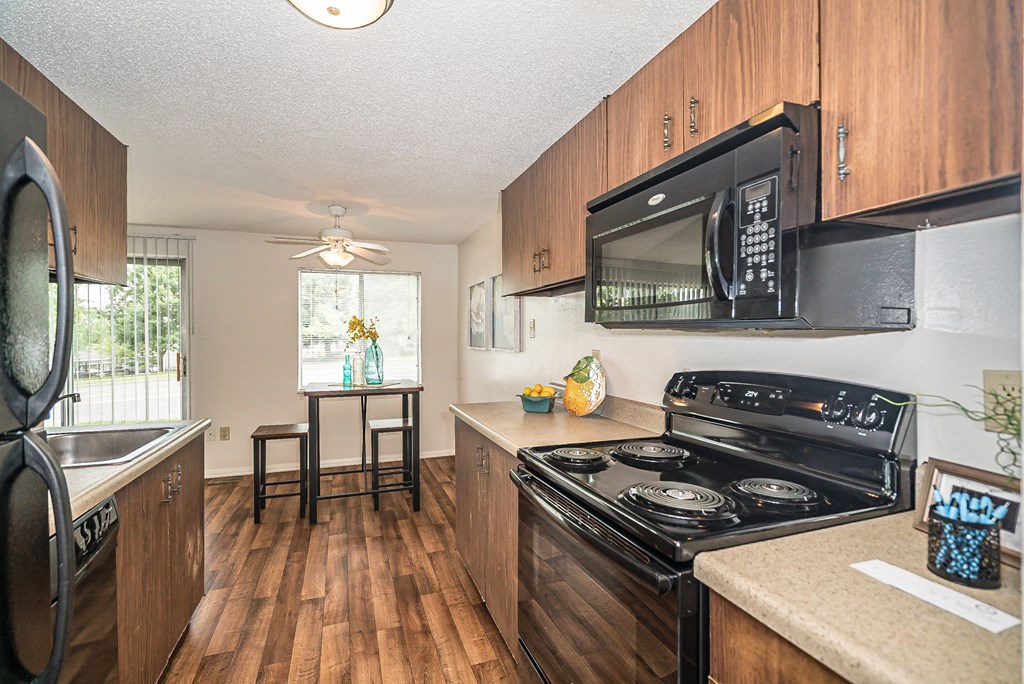 a kitchen with a stove and a microwave and a sink