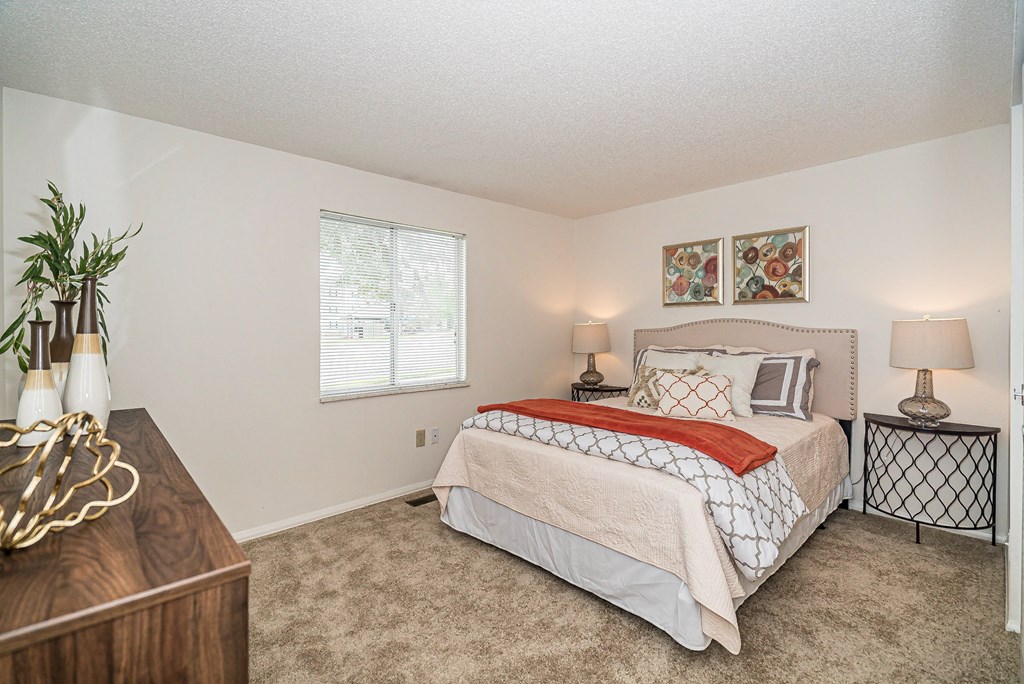 a bedroom with a bed and a dresser and a window