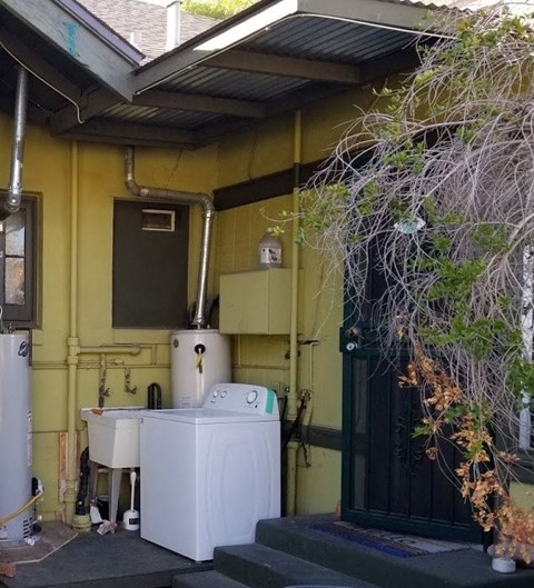 a small bathroom with a refrigerator and a washing machine