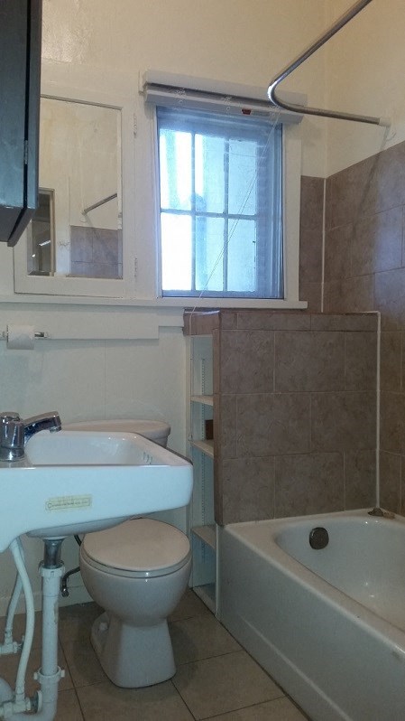 a bathroom with a toilet and a sink and a tub