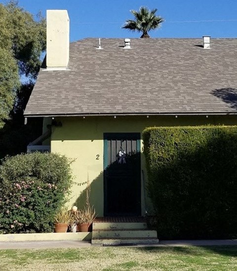 a small yellow house with a black door
