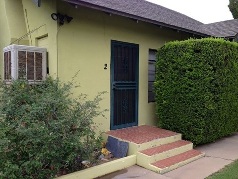a yellow house with a blue door and steps