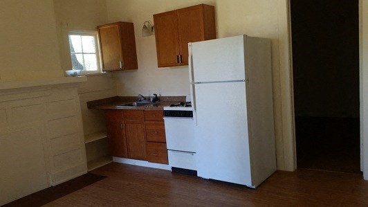 a kitchen with a white refrigerator and a sink