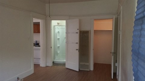 an empty living room with a door to a bathroom