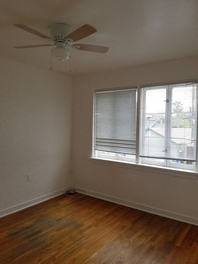 an empty room with a ceiling fan and a window