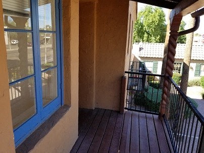 a balcony with a blue window and a wooden floor