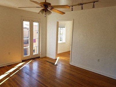 an empty living room with a ceiling fan