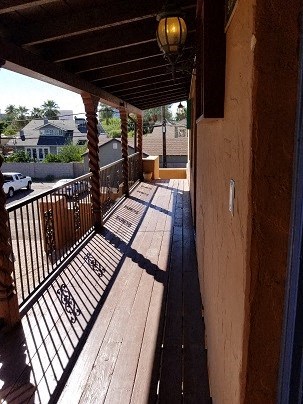a balcony with a wooden floor and a fence
