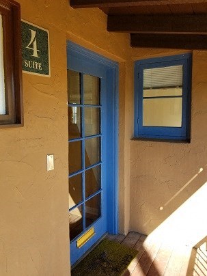 a blue door and window on a yellow building