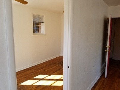 an empty room with wooden floors and a window