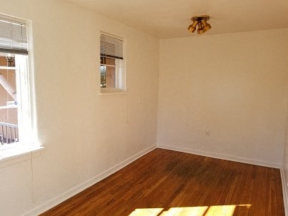 an empty room with a wooden floor and a window