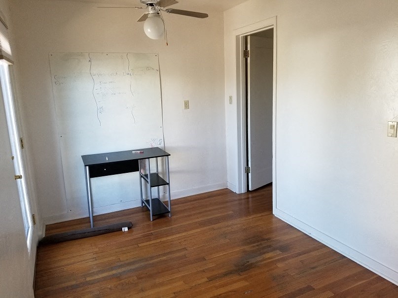 an empty room with a desk and a white wall