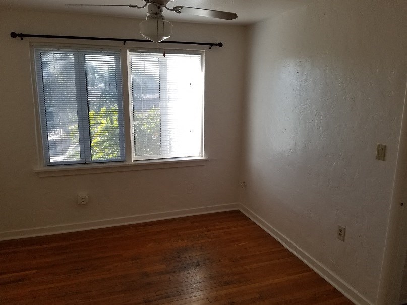 an empty room with a window and a ceiling fan