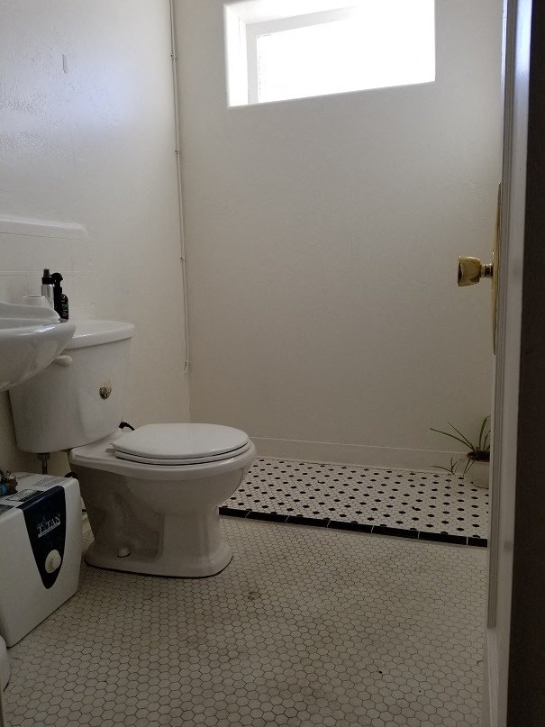 a white bathroom with a toilet and a sink