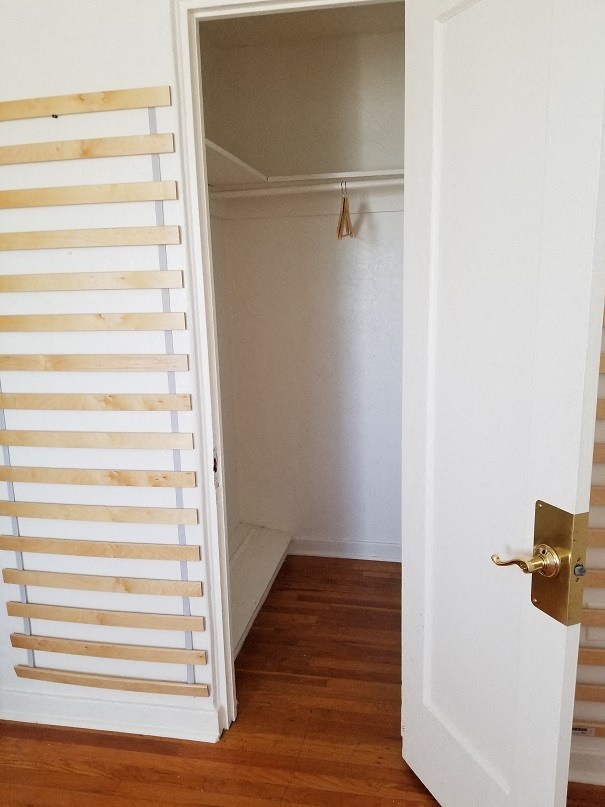 a small closet with a wooden floor and a white door