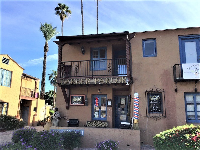 a building with a barber shop and palm trees