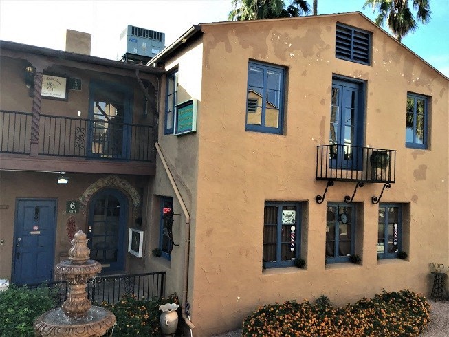 the facade of a building with blue windows and a fountain