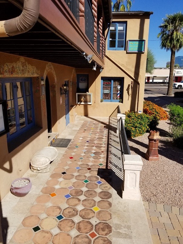 a building with a tiled sidewalk in front of it