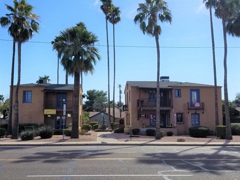 a building with palm trees in front of it on a street