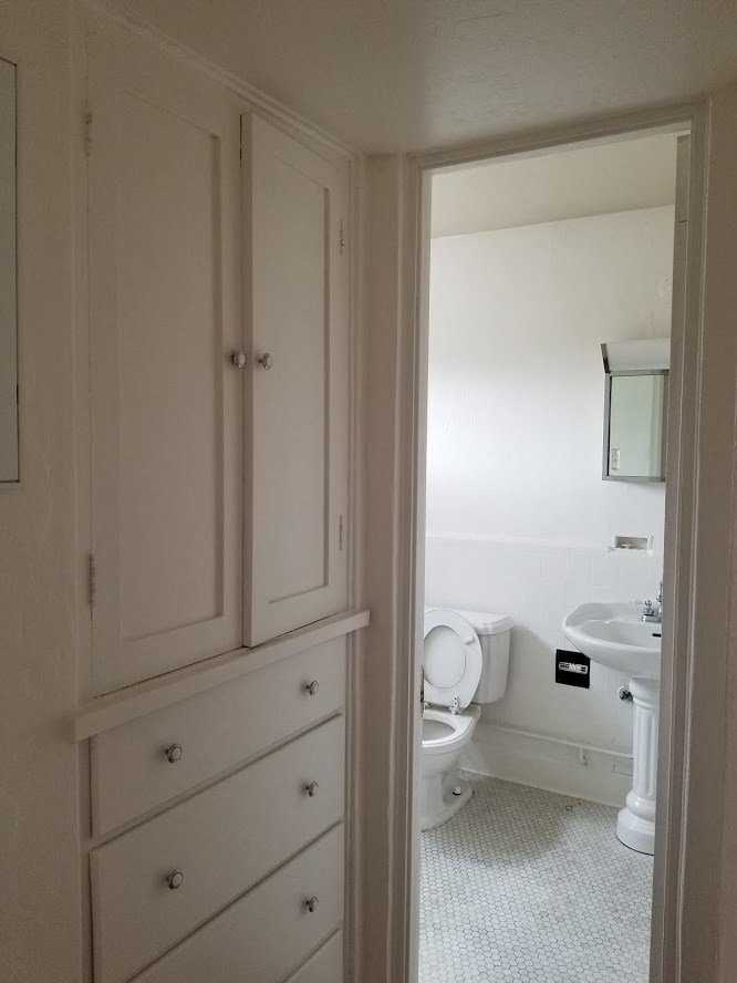 a white bathroom with a toilet and a sink