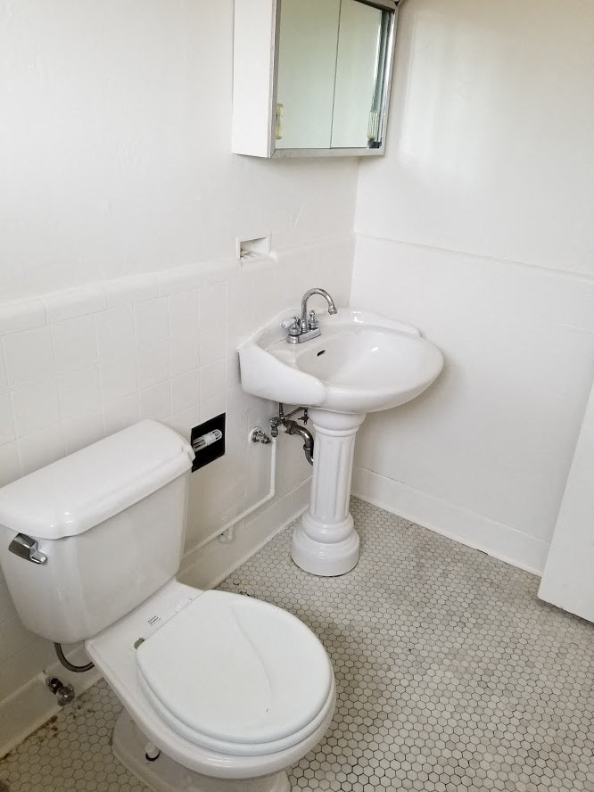a white bathroom with a toilet and a sink