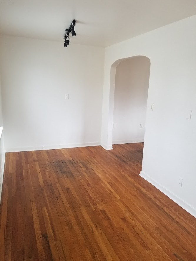 an empty room with a wooden floor and white walls