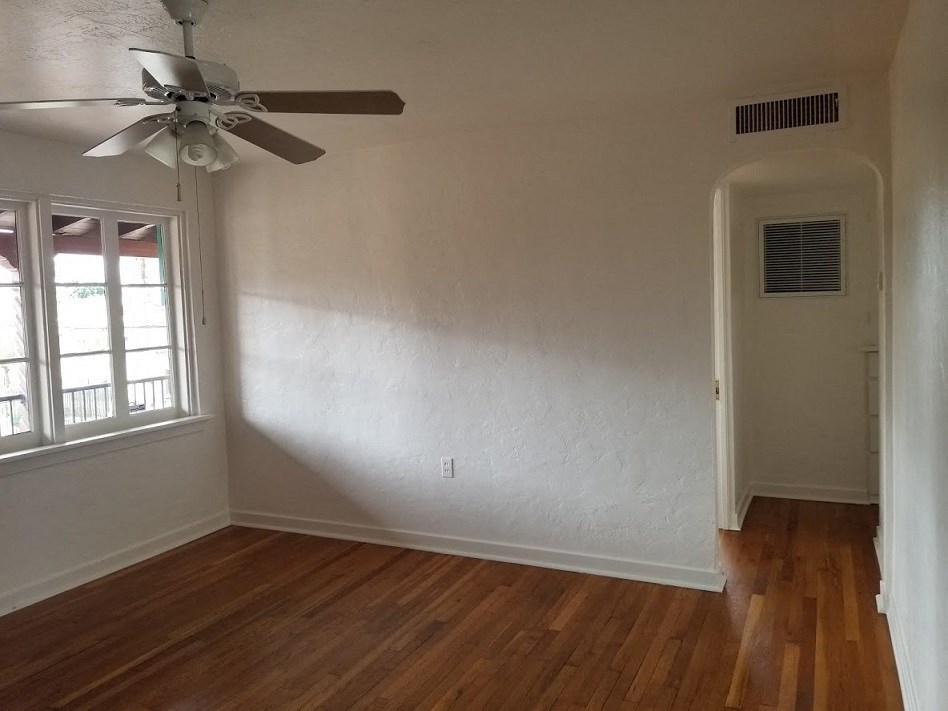 an empty room with a ceiling fan and a window