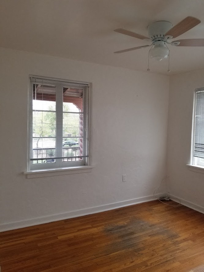 an empty room with a ceiling fan and a window