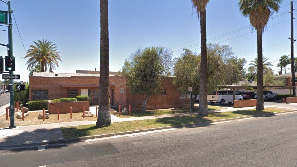 a red brick building with palm trees in front of it