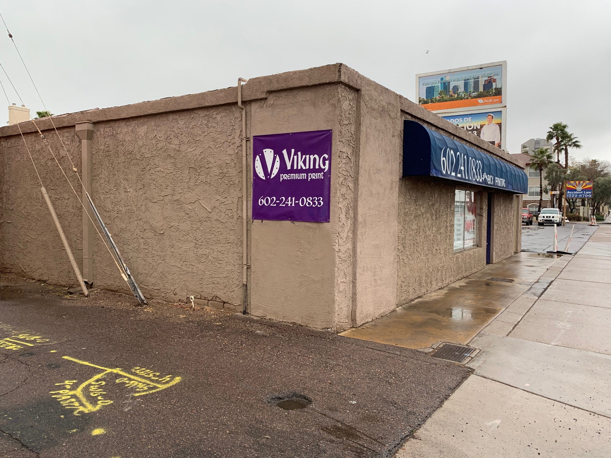 a building with a purple sign on the side of a street
