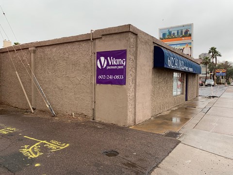 a building with a purple sign on the side of a street