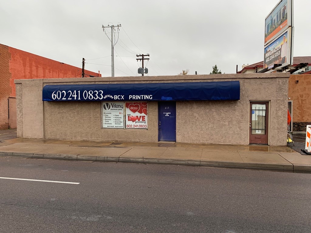 a building with a blue awning on the side of a street