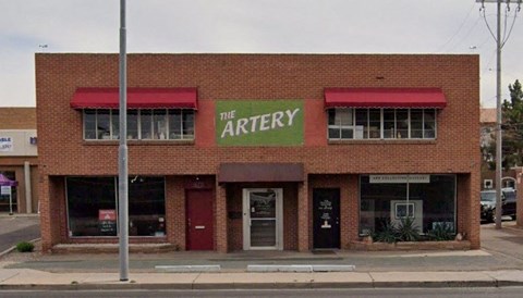 the archery restaurant is on the corner of a city street