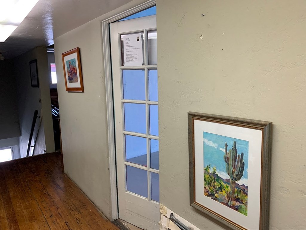 a room with a window and a picture of a cactus