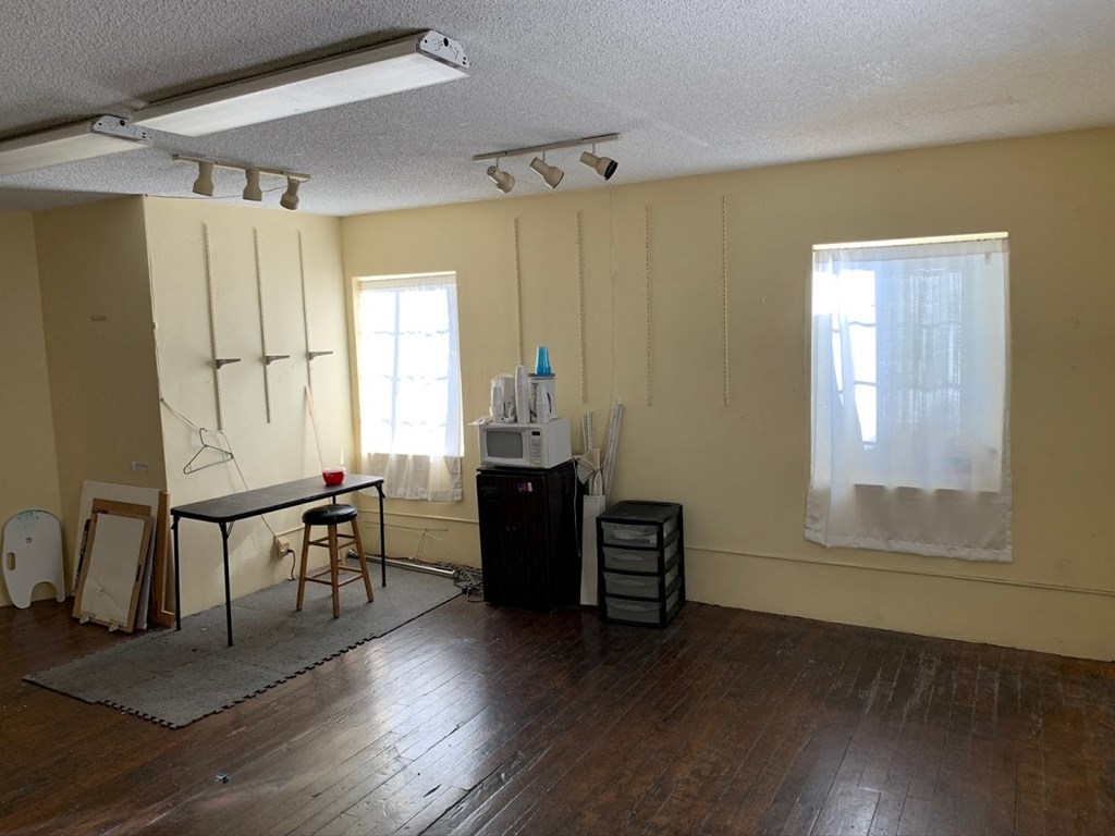 an empty room with white walls and a table and chairs