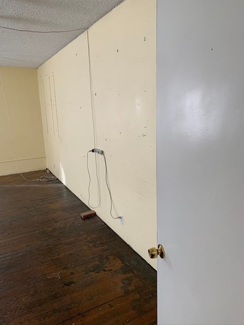 an empty room with white walls and a wooden floor