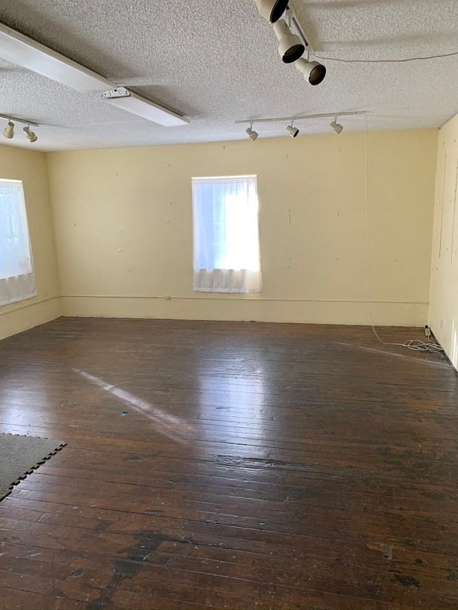 an empty room with a wood floor and a window