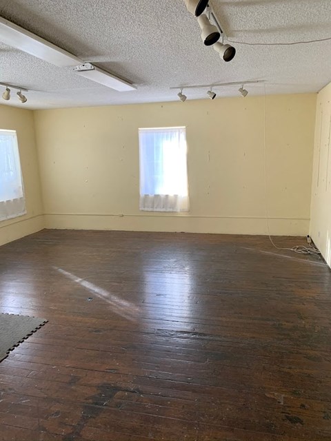 an empty room with a wood floor and a window